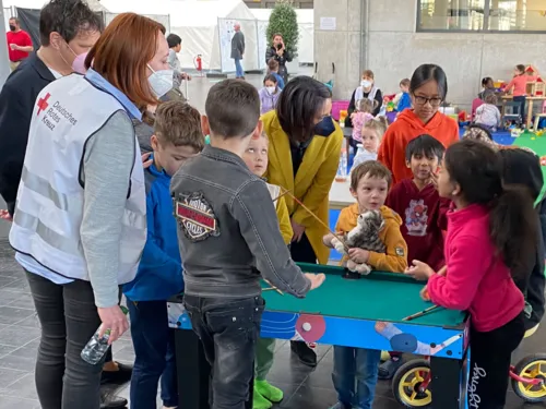 Erwachsene mit Kindern in der Flüchtlingsunterkunft Halle 27.